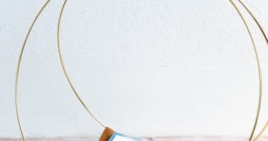DIY magazine Rack using gold macrame hoops and leather